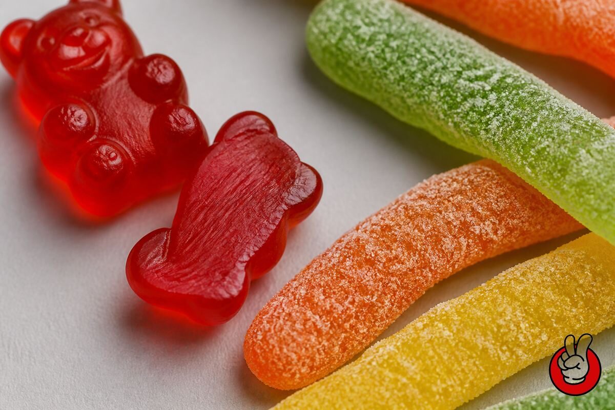 Macro views of a cut gummy's gel interior and sanded sour coating, showing how acid placement drives the release curve of sourness.